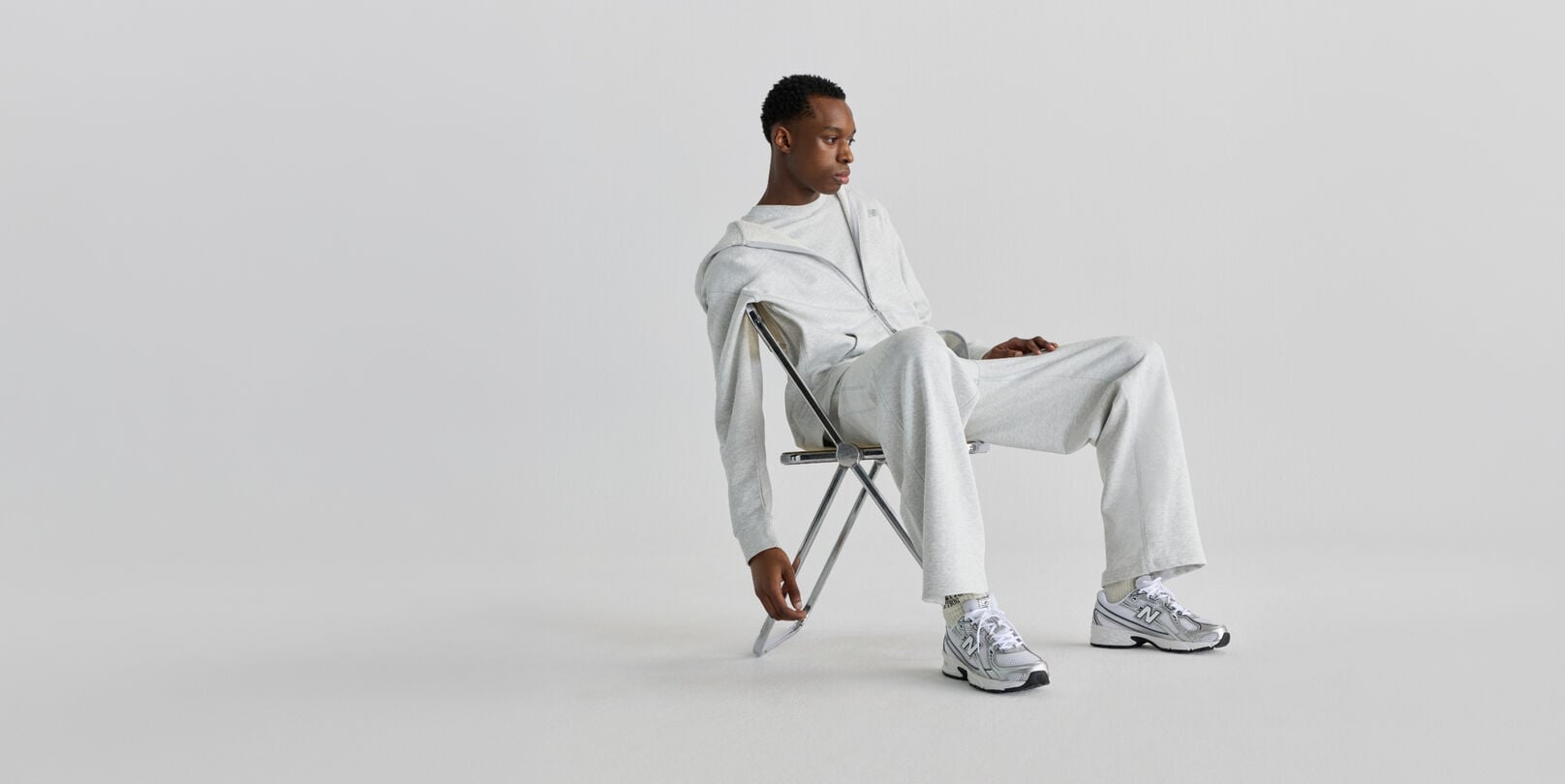 Man sitting on chair wearing New Balance