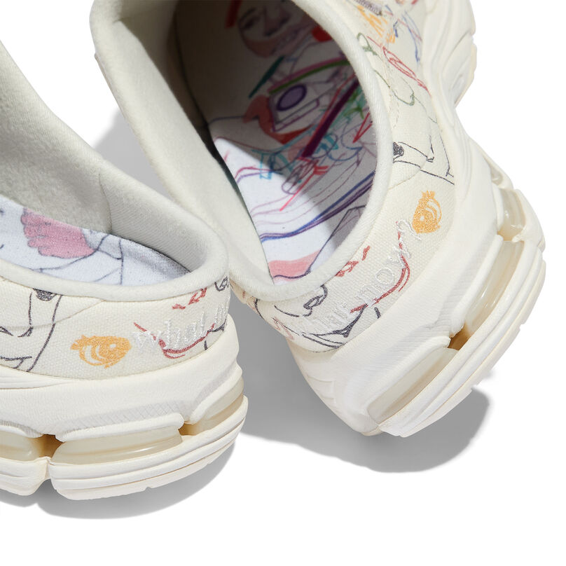 Image Alt Text 1 The heel of a pair of cream colored mule shoes with embroidered art on the shoe