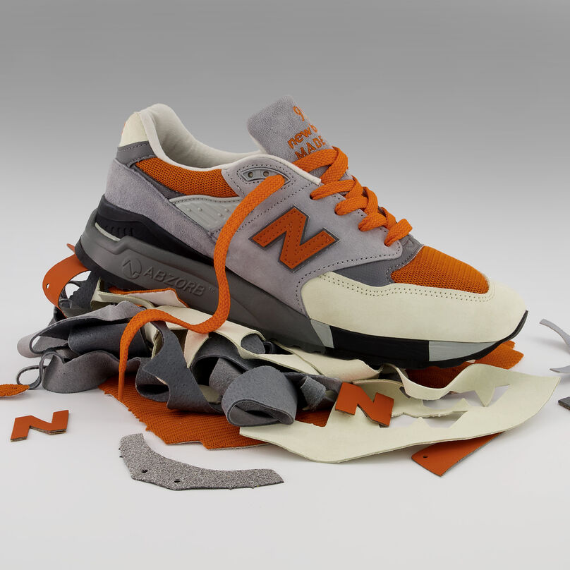 Finished orange and grey 998 sitting on top of a pile of the surplus material used to create it on a grey studio background.