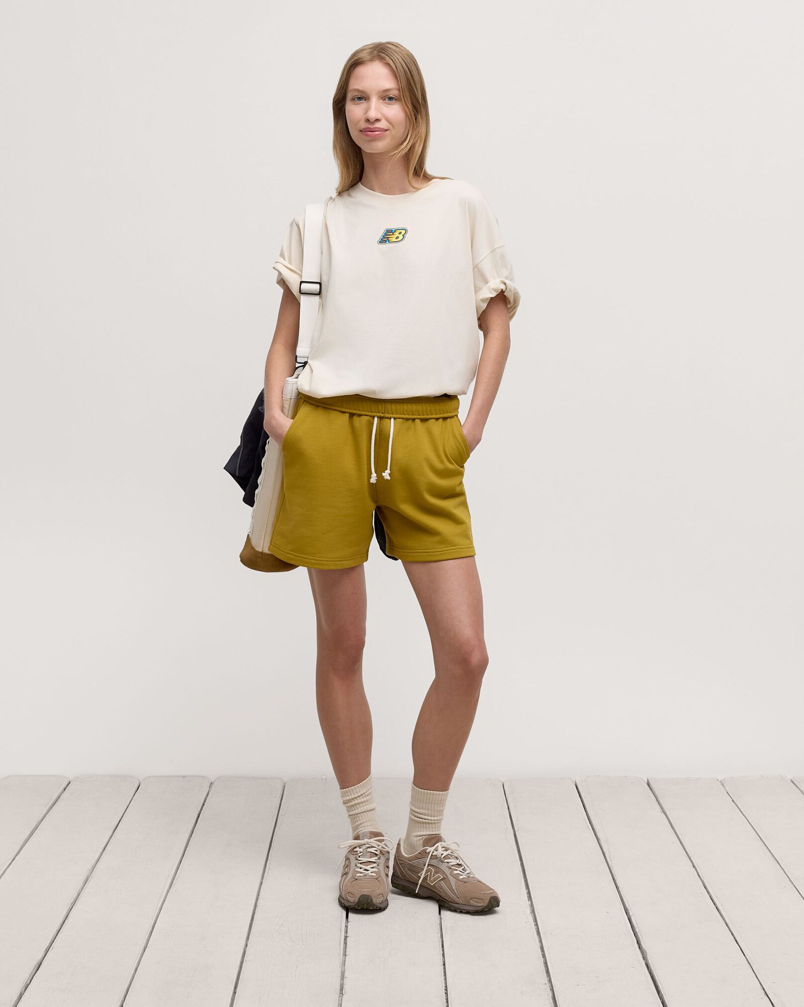 A woman standing in front a white wall.