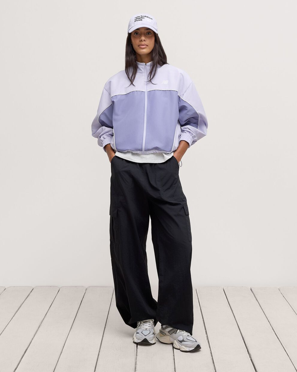 A woman standing in front a white wall.